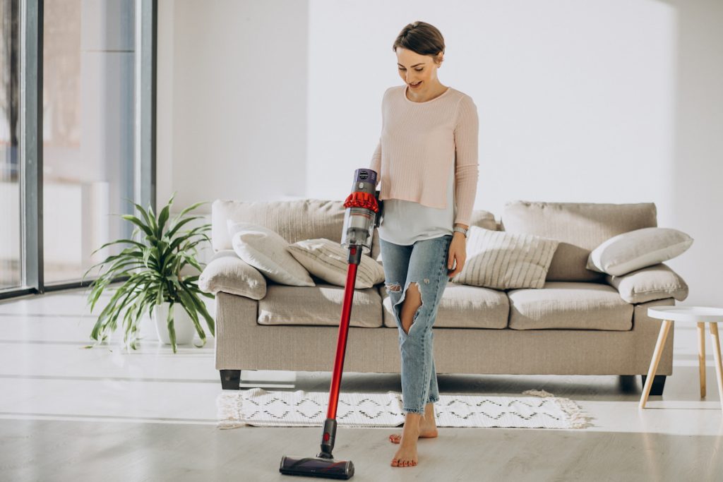 Aspirateur balai sans fil utilisé dans un salon moderne